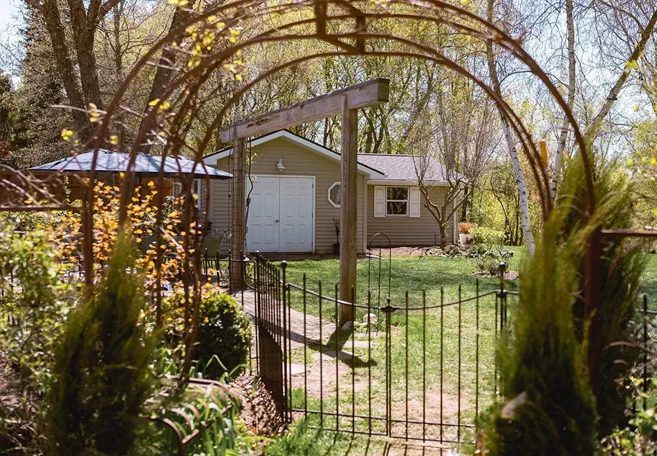 Looking at a home with a new roof through the garden gate.